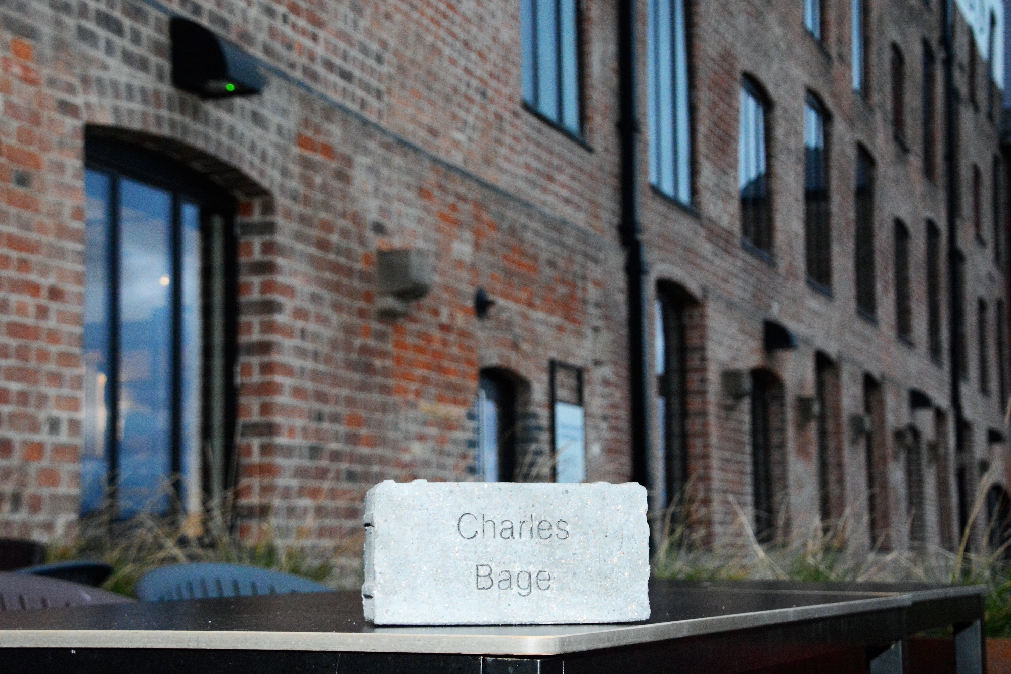 A paving brick engraved with the name Charles Bage, resting on a table outside Shrewsbury Flaxmill M